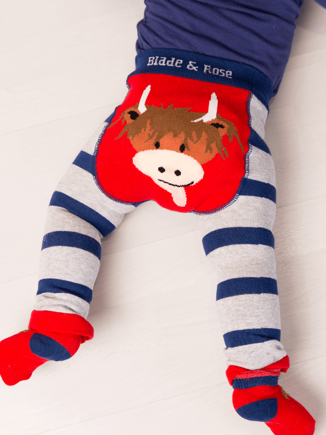 Children's leggings with cow design and striped pattern on a white background