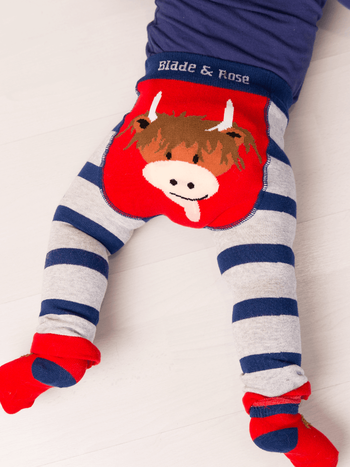 Children's leggings with cow design and striped pattern on a white background