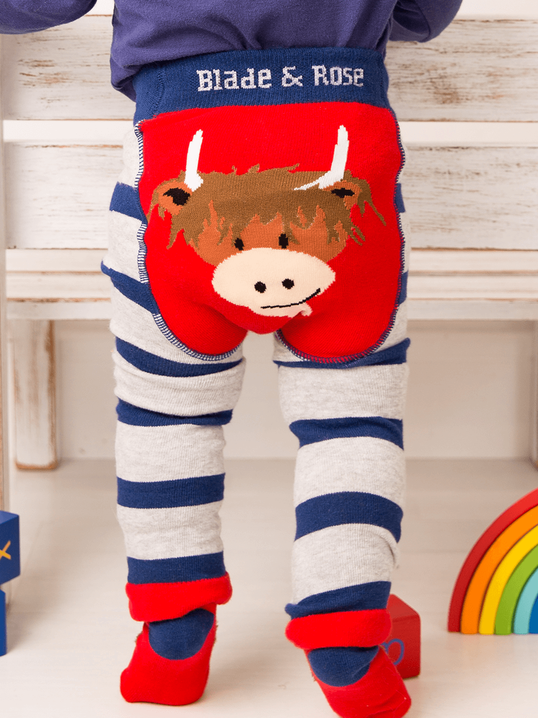 Children's leggings with a cow design and 'Blade & Rose' branding on a wooden floor.