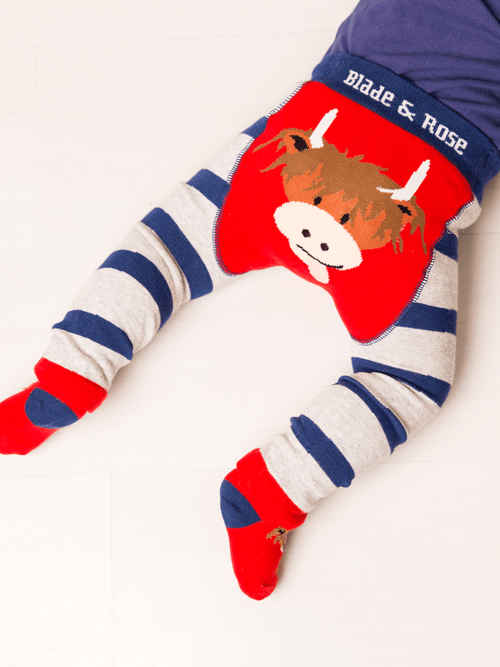 Children's leggings with cow design and striped pattern on a white background