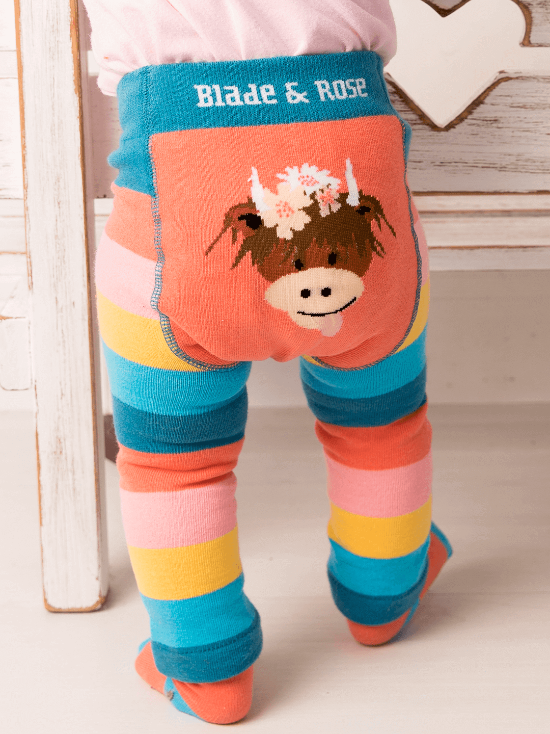 Colorful striped leggings with a cow design and 'Blade & Rose' branding.