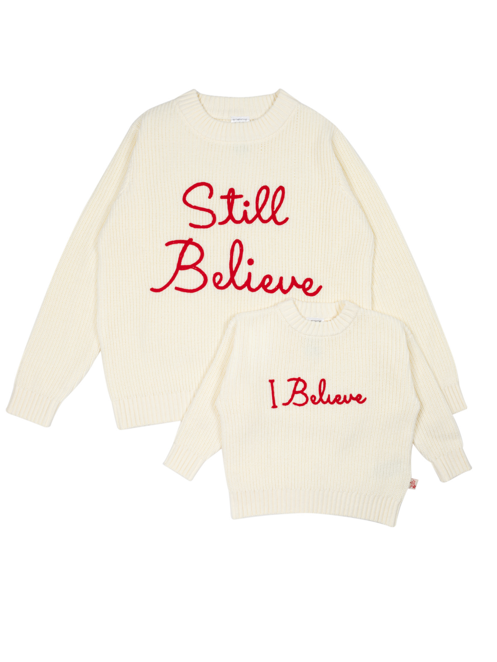 Still Believe adult jumper and I Believe kids jumper in cream with red embroidery, laid flat